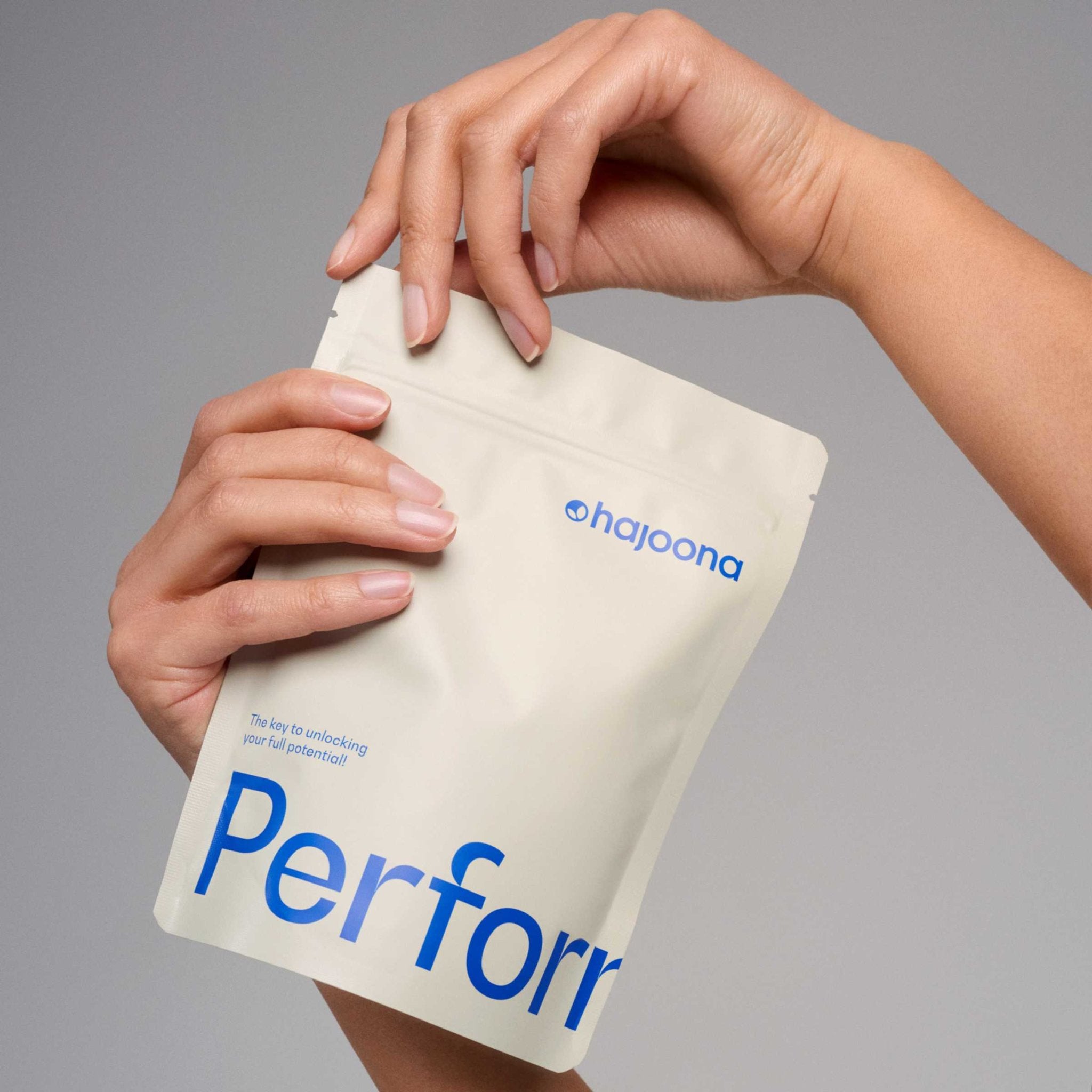 Das Bild zeigt eine Hand, die einen Standbeutel des hajoona Performance Produkts hält. Dieses Nahrungsergänzungsmittel enthält eine sorgfältig zusammengestellte Rezeptur, die unter anderem den Vitalpilz Cordyceps sinensis und Inulin aus der Zichorie umfasst. Die praktische Standbeutel-Verpackung ermöglicht eine einfache Dosierung und ist ideal für den täglichen Gebrauch.